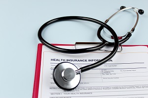 stethoscope on top of health insurance paperwork